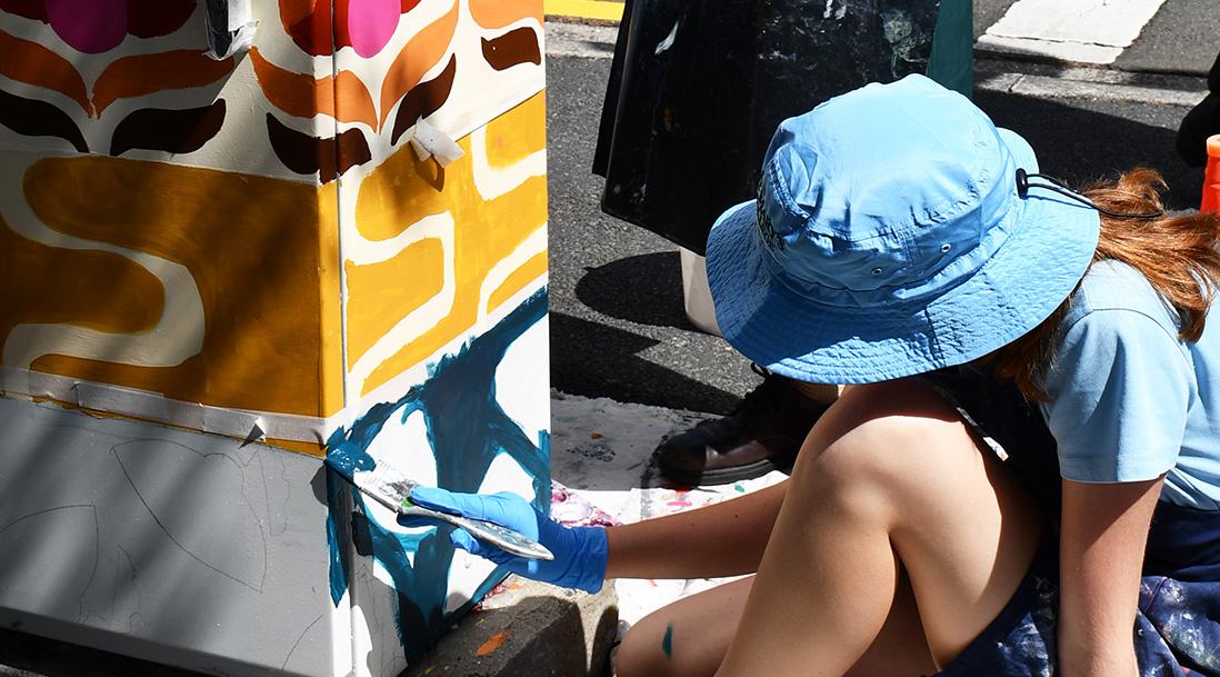 Students painting a traffic signal box in Nipaluna/Hobart, Lutruwita/Tasmania
